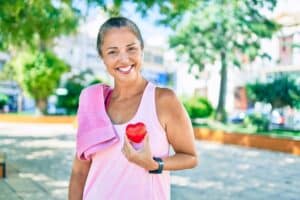 woman holding healthy heart on shirt after preventative care exercise